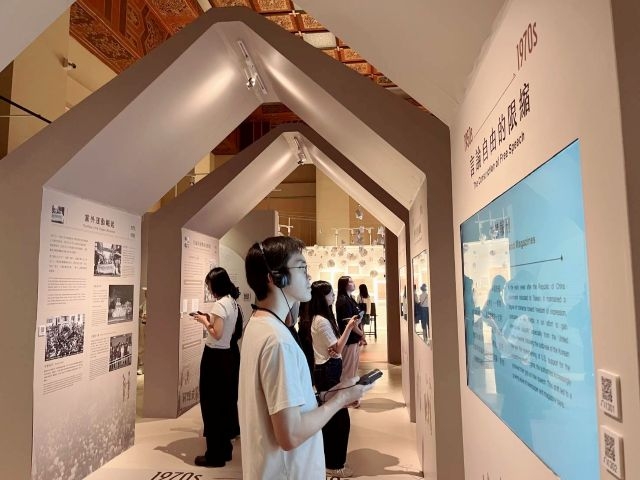觀眾在「自由花蕊展」認真聆聽語音導覽解說。 觀眾在「自由花蕊展」認真聆聽語音導覽解說。